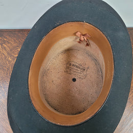 Black Silk Top Hat manufactured by the Buzolich Family, Melbourne between 1910 – 1927 (now City Hatters Flinders Street). Includes original Leather Hat Box with insert for hat. Hat in good condition, box shows wear and deterioration commensurate with age and has part labels from travel affixed.