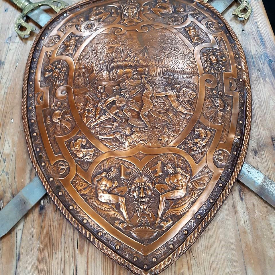 An Antique Very Detailed Embossed Copper Shield with Swords