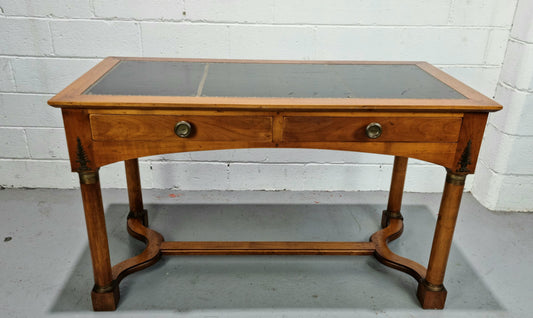 Empire style Walnut desk with pull-out slides and two drawers. It has its original gold tooled leather top and is from circa 1920's. It is in good original detailed condition.