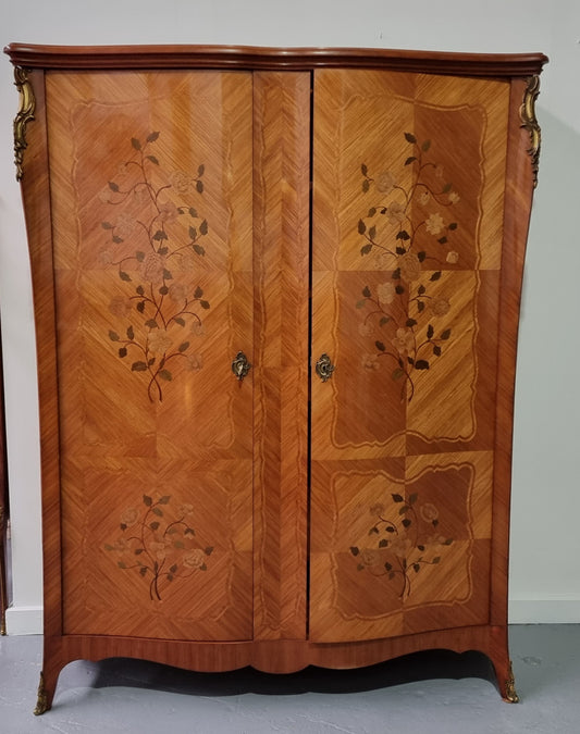 Tall French Marquetry inlaid armoire / bookcase with ormolu mounts. The interior has six fully adjustable shelves and two drawers. It is in good original detailed condition.