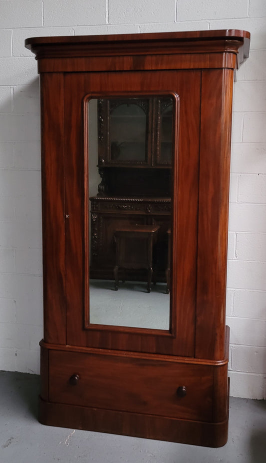 A beautiful and practical Antique Mahogany mirrored single door and drawer wardrobe. Plenty of hanging space and added storage with a drawer at the bottom. It is in good original condition with working lock and key.