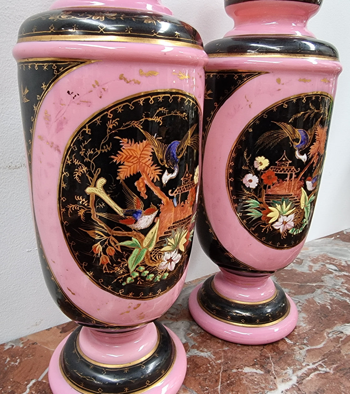 Late Victorian pink and hand painted, enameled pair of vases with some ware to enameling. It is in good original condition.