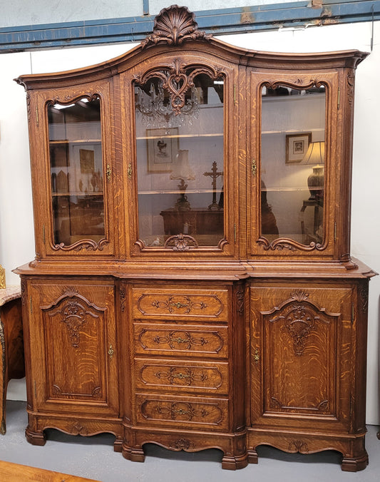 Impressive French Oak Louis 14th Style Display and Sideboard. It has 4 drawers, 2 bottom cupboards with 6 total shelves and 3 display doors with 3 shelves.  In good, detailed condition.