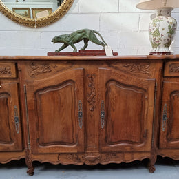 Parquetry top French oak Louis XV style sideboard with two draws and four cupboards. In good original detailed condition.