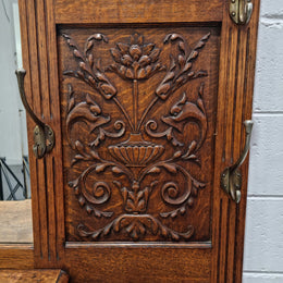 Grand Henry 2nd Style French Oak hall stand with 12 hanging hooks. Also has one cupboard and drawer for storage along with a mirror and two areas either side for umbrellas and walking sticks. In good original detailed condition.