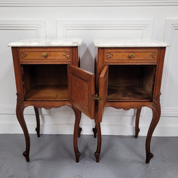 Pair of French Antique Louis XV style Oak marble top night stands. They have beautiful carved cabriole legs and beautiful white marble along with a drawer and cupboard for storage space. They have been sourced from France and are in good original detailed condition.