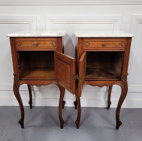Pair of French Antique Louis XV style Oak marble top night stands. They have beautiful carved cabriole legs and beautiful white marble along with a drawer and cupboard for storage space. They have been sourced from France and are in good original detailed condition.