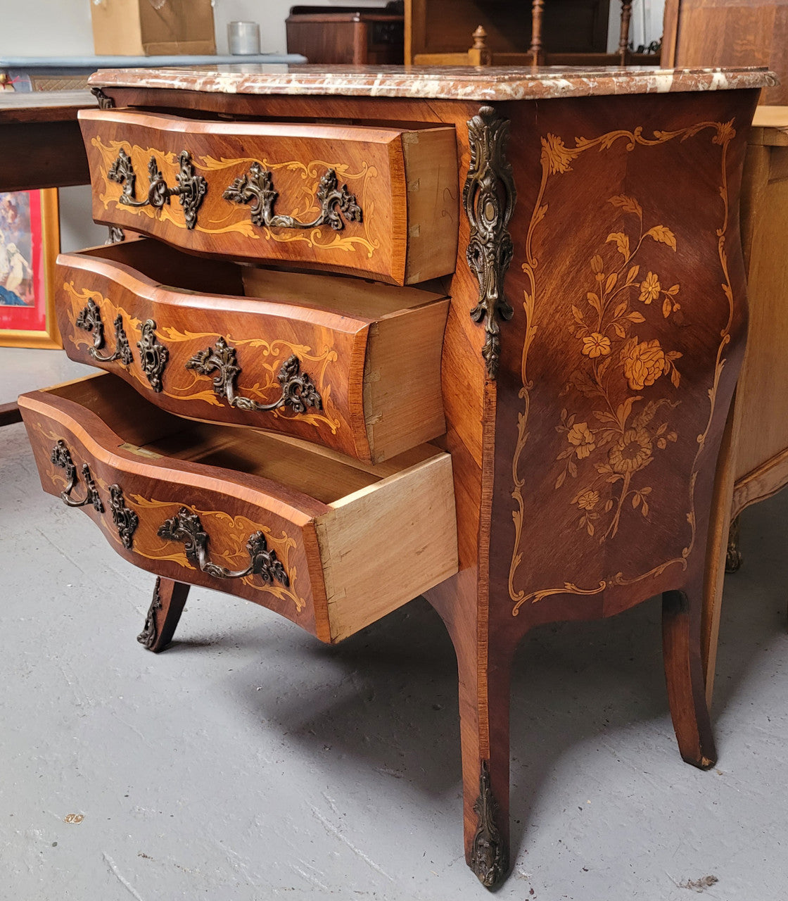 Antique French Louis XV style compact three drawer marble top commode with marquetry inlay and ormolu mounts. Sourced from France and in good original detailed condition.