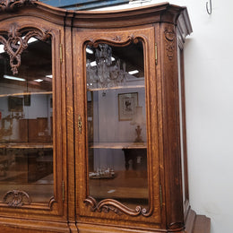 Impressive French Oak Louis 14th Style Display and Sideboard. It has 4 drawers, 2 bottom cupboards with 6 total shelves and 3 display doors with 3 shelves.  In good, detailed condition.