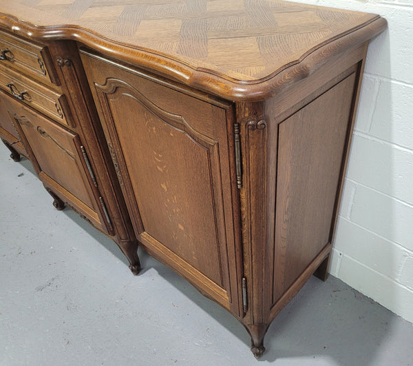 French Louis XV style parquetry top three door sideboard with two drawers. Plenty of storage space with a shelf behind each door. It is in good original detailed condition.