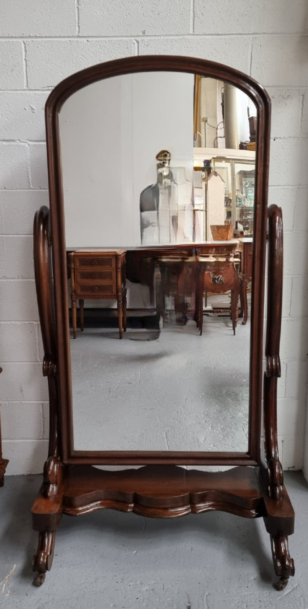 Antique Victorian 19th Century full length Mahogany cheval mirror. Mirror supported on two elegant scrolled upright support and stands on moulded base with four scrolled feet and castors.