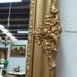 A French transitional Louis XV/Louis XVI style, gilded hanging wall mirror. In good restored condition.