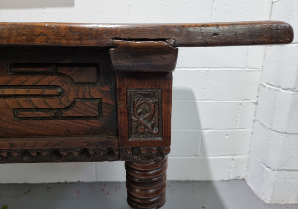 Rare and Charming 17th Century Spanish Walnut serving / side table. It has an incredible one piece walnut top with amazing character and colour. The base displays the original patina aswell as three drawers with carving and remnants of original locks. Superbly turned legs terminating on a stretcher base. Could be used as a large entrance console table, a side table or in a dining area as a serving table. In good original detailed condition especially considering its age.
