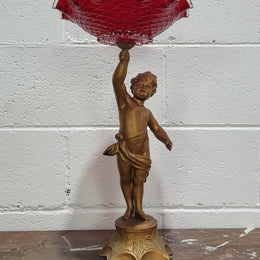 Late Victorian spelter table centerpiece/comfort featuring putti holding ruby glass bowl. In good original condition with no damage to the glass.