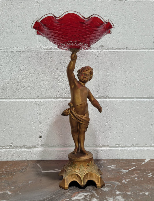 Late Victorian spelter table centerpiece/comfort featuring putti holding ruby glass bowl. In good original condition with no damage to the glass.
