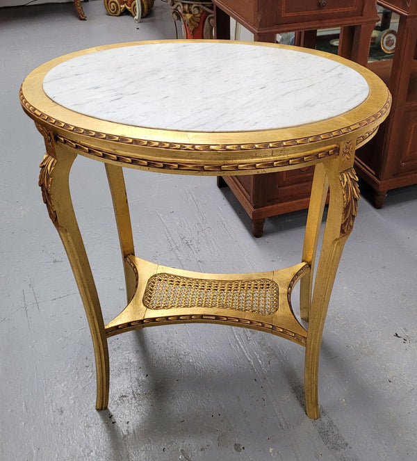 Impressive French oval Louis XVI style gilt and white marble topped two tier lamp/side table. It has been sourced from France and is in good original detailed condition.