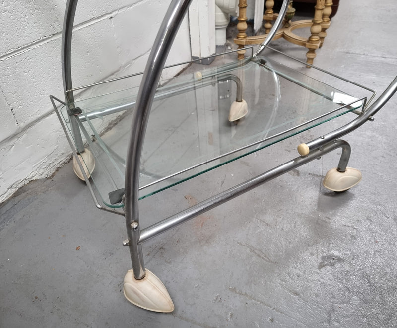 Stylish Art Deco chrome & frosted glass drinks trolley. Bakelite guards on the wheels. It is in good original condition and has been sourced locally.