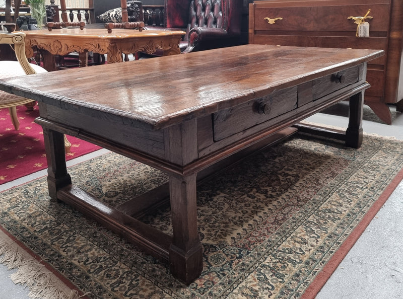 Impressive large size rustic French Oak coffee table with two drawers on a stretcher base. In good original detailed condition and sourced from France.