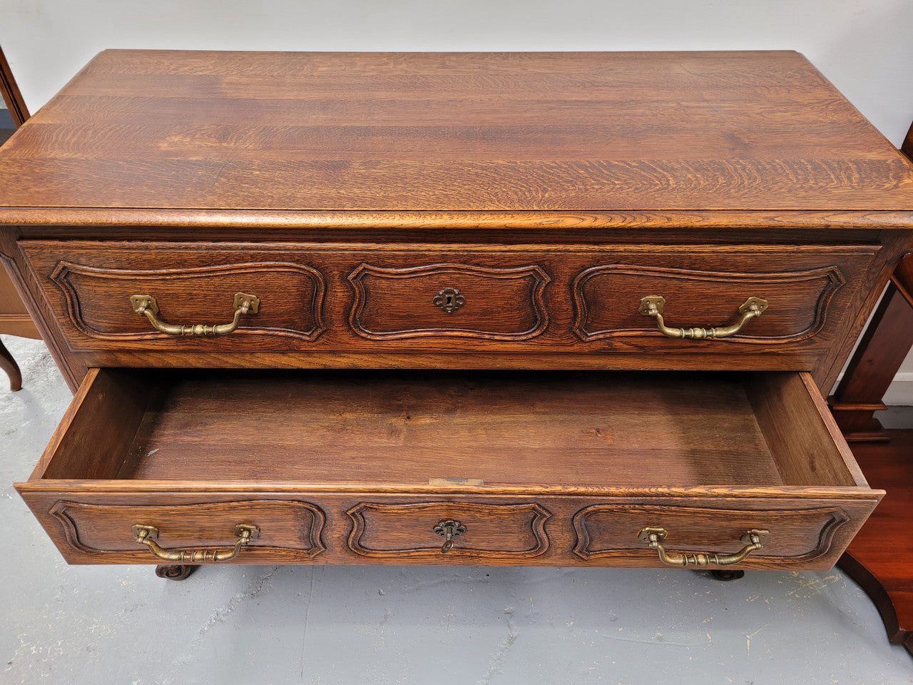 French Provincial Oak three drawer wooden top commode. It has elegant carvings and handles. It has been sourced from France and is in good original detailed condition.
