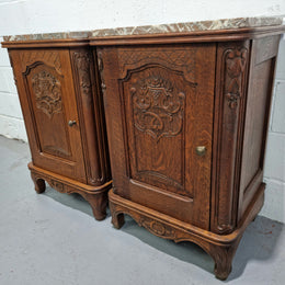 Lovely pair of French oak bedside cabinets with nicely carved details and marble tops. In good original detailed condition.