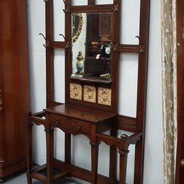 Beautiful English Edwardian tiled back hall stand, with nine brass hooks, two small drawers and retaining it's original mirror and showing signs of age. In good original condition.