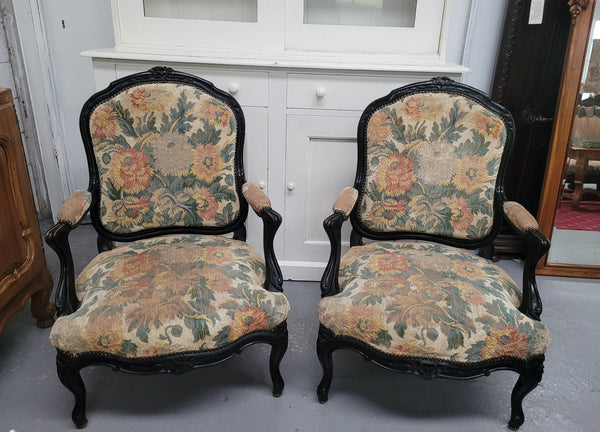 Antique 19th century Louis XV style ebonized upholstered armchairs. The fabric is in good used condition showing signs of use. They can be used as is or reupholstered for a new look.
