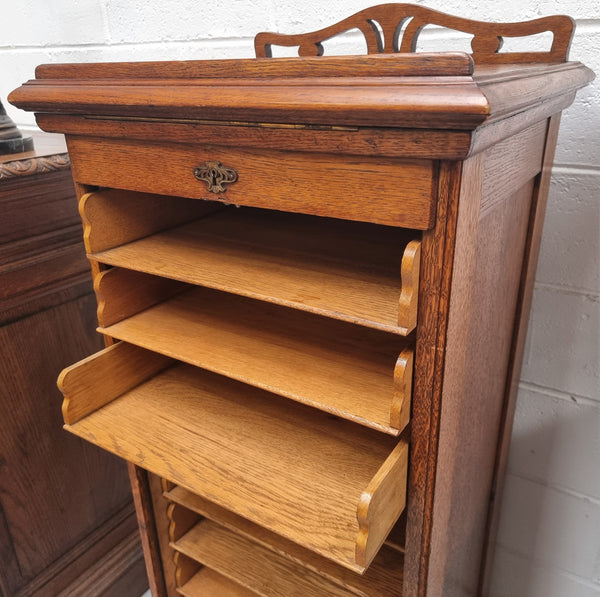 Antique Edwardian roll top Tambour file cabinet desk. This practical antique tambour front filing cabinet dates around 1900 in the Edwardian period and is constructed from Oak. This antique cabinet has an adjustable writing slope, above a tambour front with key and working lock. It has been sourced locally and is in good original detailed condition.