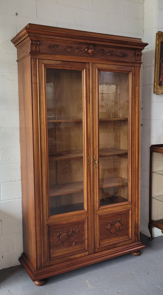 Stunning French Walnut Henry II style two door bookcase with four fully adjustable shelves. The lock on the door is functional and has a key. It is in good original detailed condition.