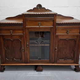 Lovely Oak Tudor style rope edge sideboard with leadlight center door, three drawers and two solid cupboards. In good original condition.