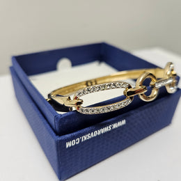 Swarovski gold toned fitted bangle set with Swarovski crystals. Swarovski mark to band, and a side opening. Charming little bracelet. Please see photos as they form part of the description.