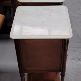 Pair of white marble topped Louis 16th style bedside cabinets consisting of one drawer and one cupboard.  Inlaid with burr walnut and has decorative mounts. They have been sourced from France and are in good original condition.