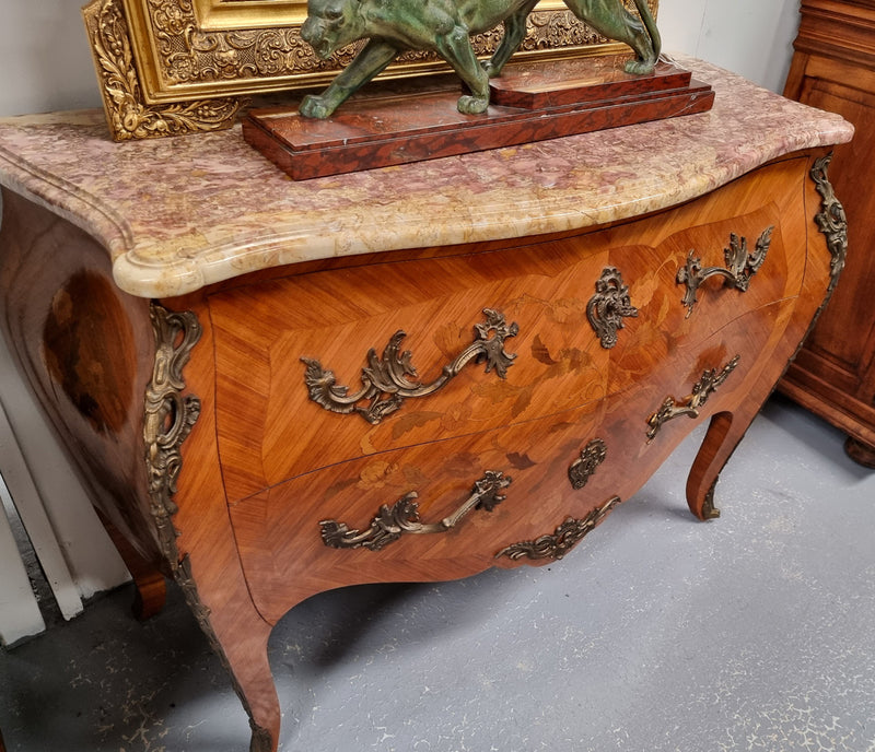 Attractive French Louis XV style walnut two drawer marquetry inlaid commode. With impressive ormolu handles and trims and shaped marble top. It has been sourced from France and is in good original detailed condition.