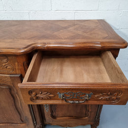 Parquetry top French oak Louis XV style sideboard with two draws and four cupboards. In good original detailed condition.