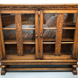 Lovely Two door bookcase sourced from France with two adjustable shelves on each side and of narrow proportions. It also has lovely detail carving and  in good original detailed condition.