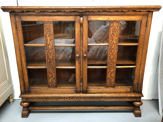 Lovely Two door bookcase sourced from France with two adjustable shelves on each side and of narrow proportions. It also has lovely detail carving and  in good original detailed condition.