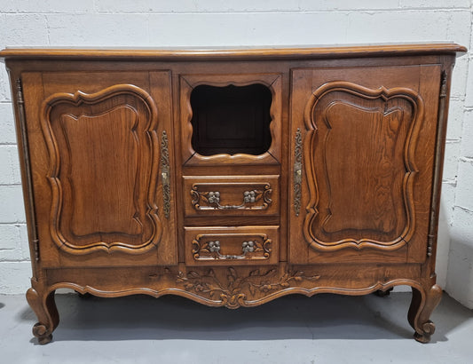 Lovely Louis XV style French Oak carved sideboard with two drawers and two cupboards for all your storage needs. It has a nice coloured marble top and in good original detailed condition.