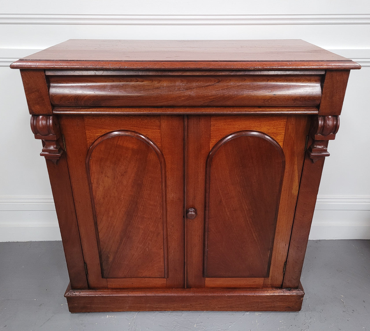 Cedar side cabinet with two doors one drawer and lovely door panels and corbels. It has been sourced locally and is in good original detailed condition.