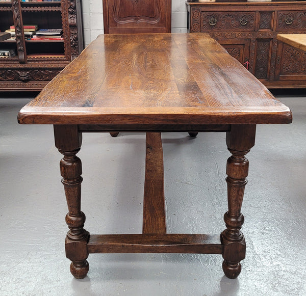 Rustic French Oak stretcher based farmhouse dining table that comfortably seats 6-8 people. It has been sourced from France and is in good original condition.