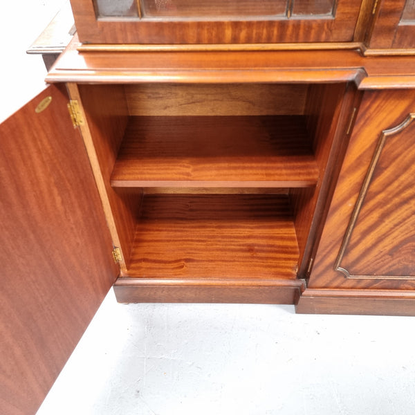 Georgian style Breakfront Flame Mahogany four door bookcase. A very impressive piece with plenty of storage and is of pleasing narrow proportions. It has been sourced locally and is in good original detailed condition.