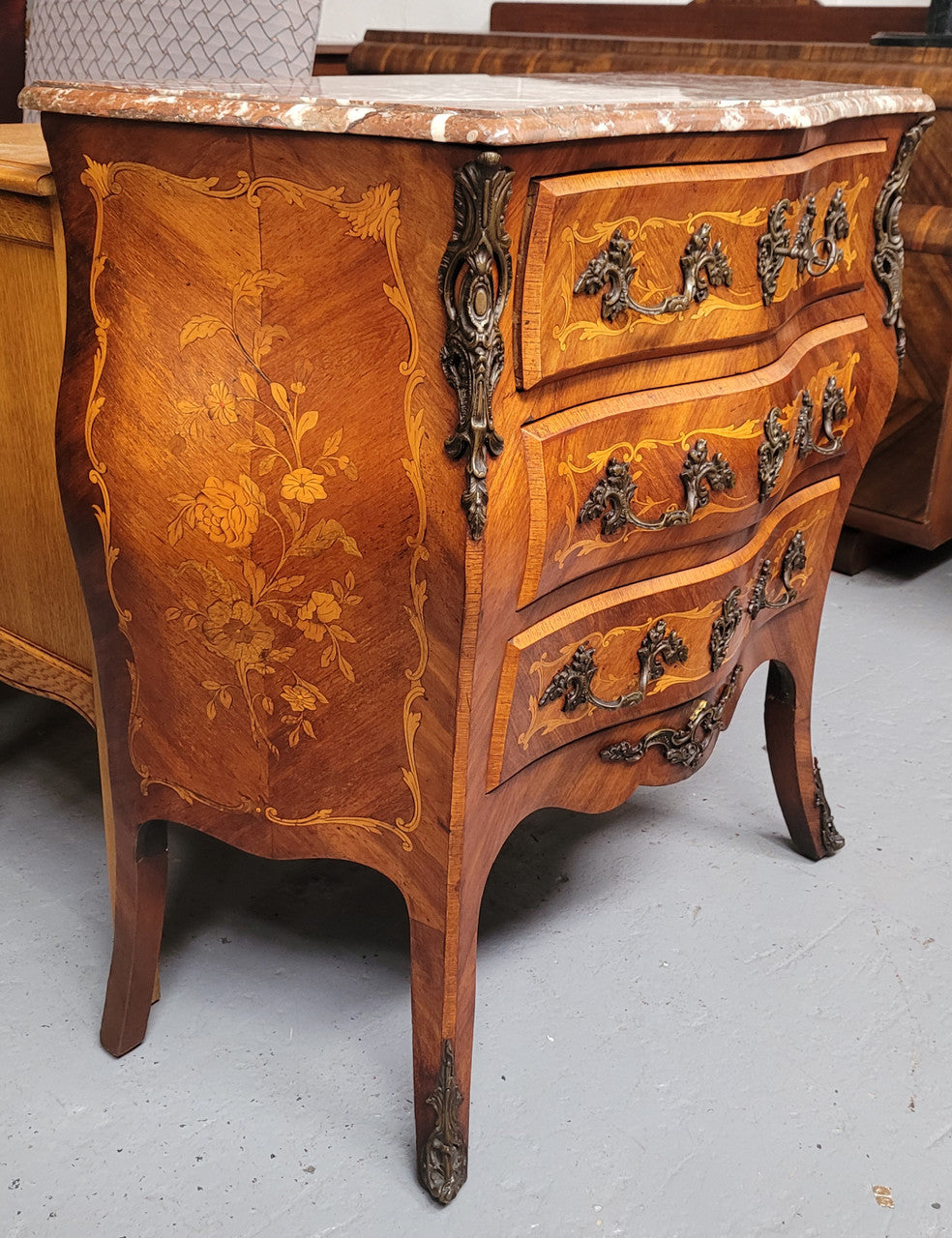 Antique French Louis XV style compact three drawer marble top commode with marquetry inlay and ormolu mounts. Sourced from France and in good original detailed condition.