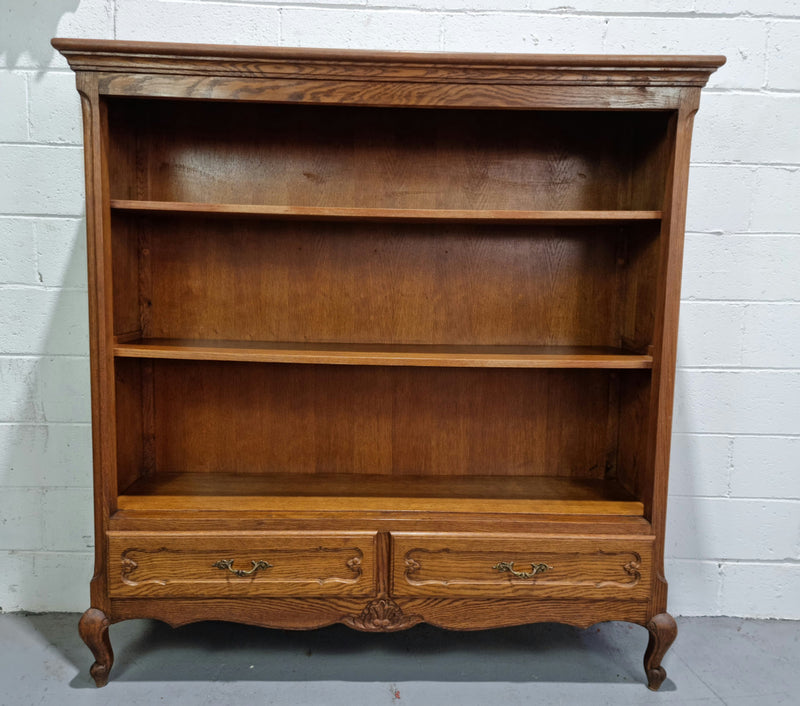 Lovely French Oak Louis XV style open shelf bookcase with two drawers for storage and three shelves in good original detailed condition.