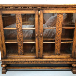 Lovely Two door bookcase sourced from France with two adjustable shelves on each side and of narrow proportions. It also has lovely detail carving and  in good original detailed condition.