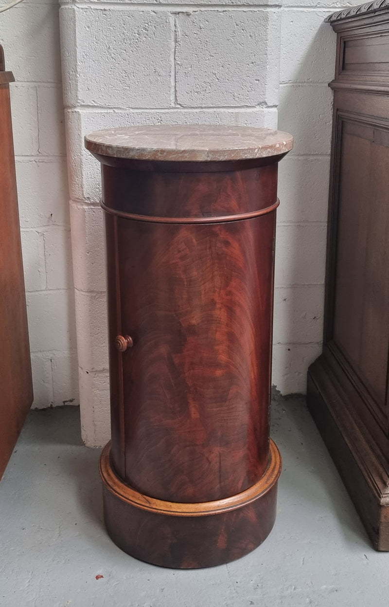 Unusual Empire flame Mahogany cylindrical marble topped bedside/pedestal. Would make an ideal pedestal with added storage inside or could be used as a bedside. Sourced from France and is in good original detailed condition.