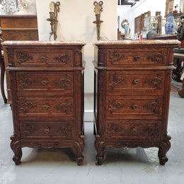 A pair of hard to find French Oak Louis XV style four drawer marble topped bedsides with attractive carvings. They are in good original detailed condition and have been sourced from France.