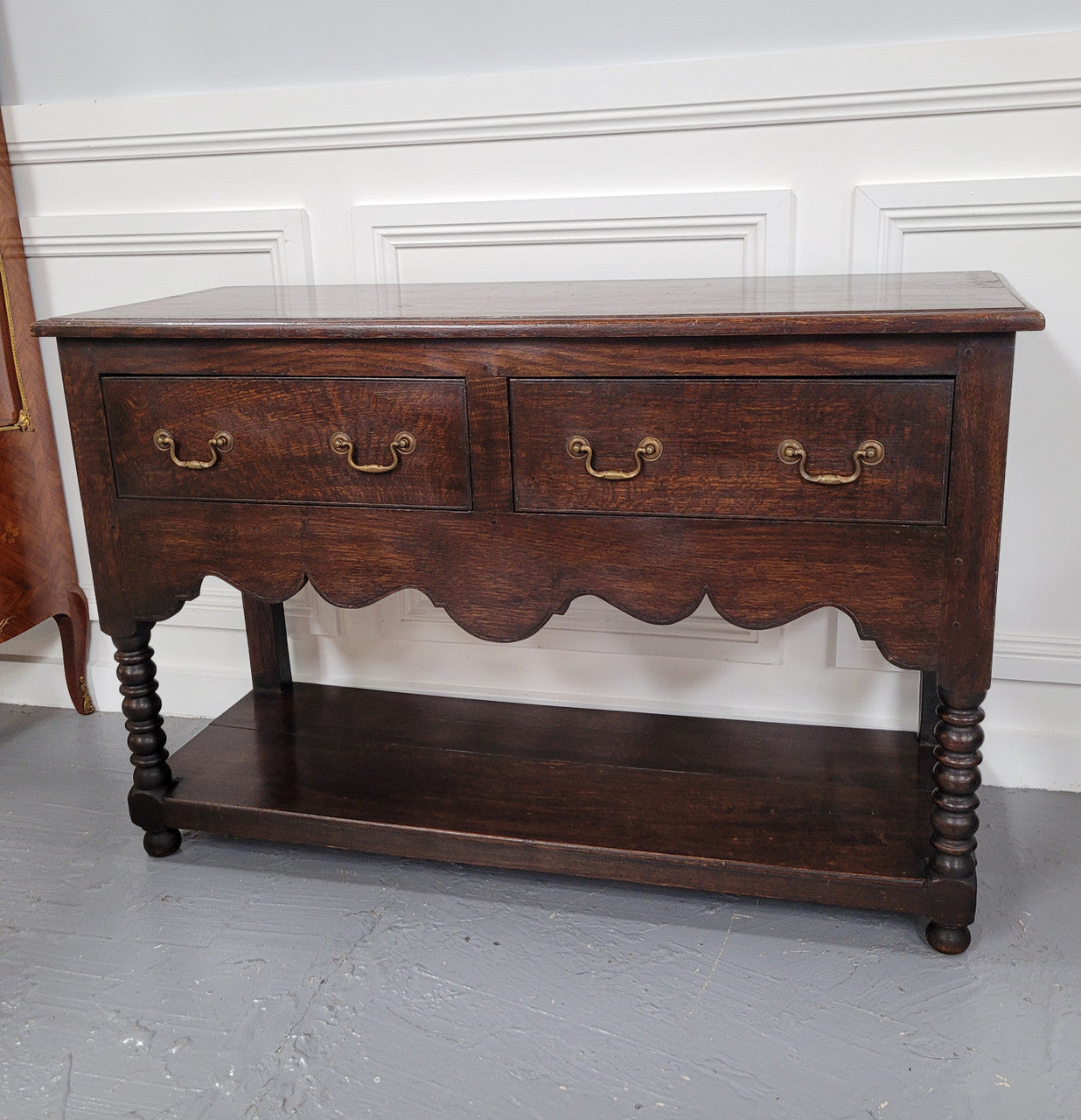 Rare size 19th Century English oak dresser base. It has two good size drawers and amazing patina. It has been sourced from France and in good original detailed condition.