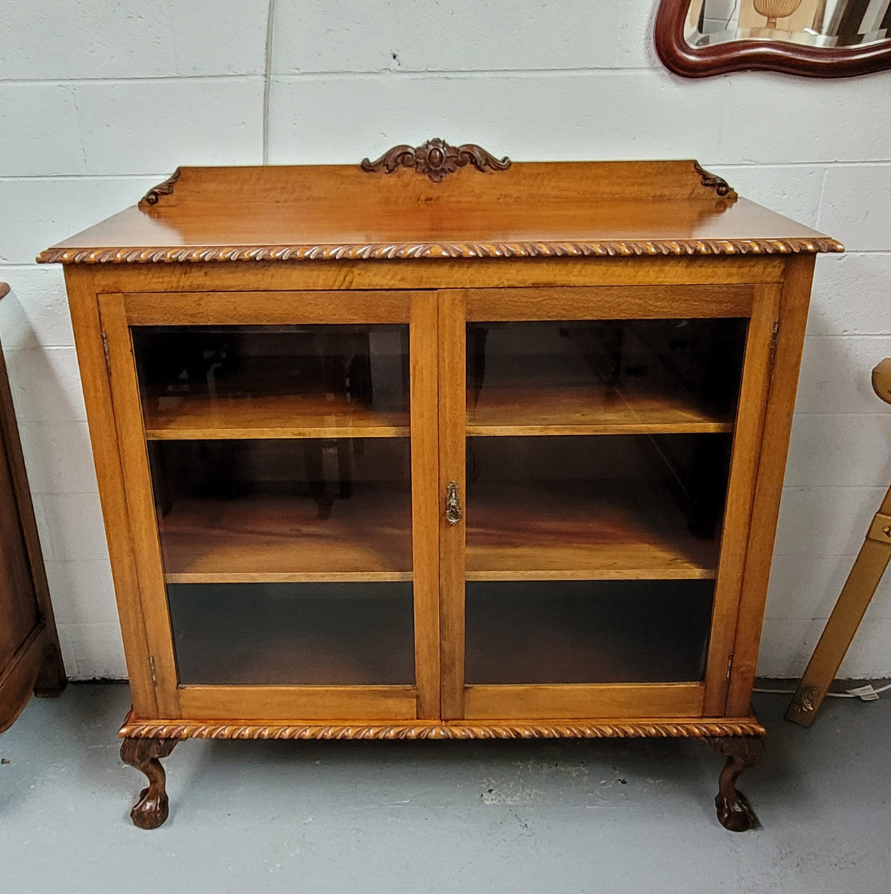 Chippendale style Mahogany two door bookcase. It has bevelled glass doors and two adjustable shelves. It has been sourced locally and is in good original detailed condition.