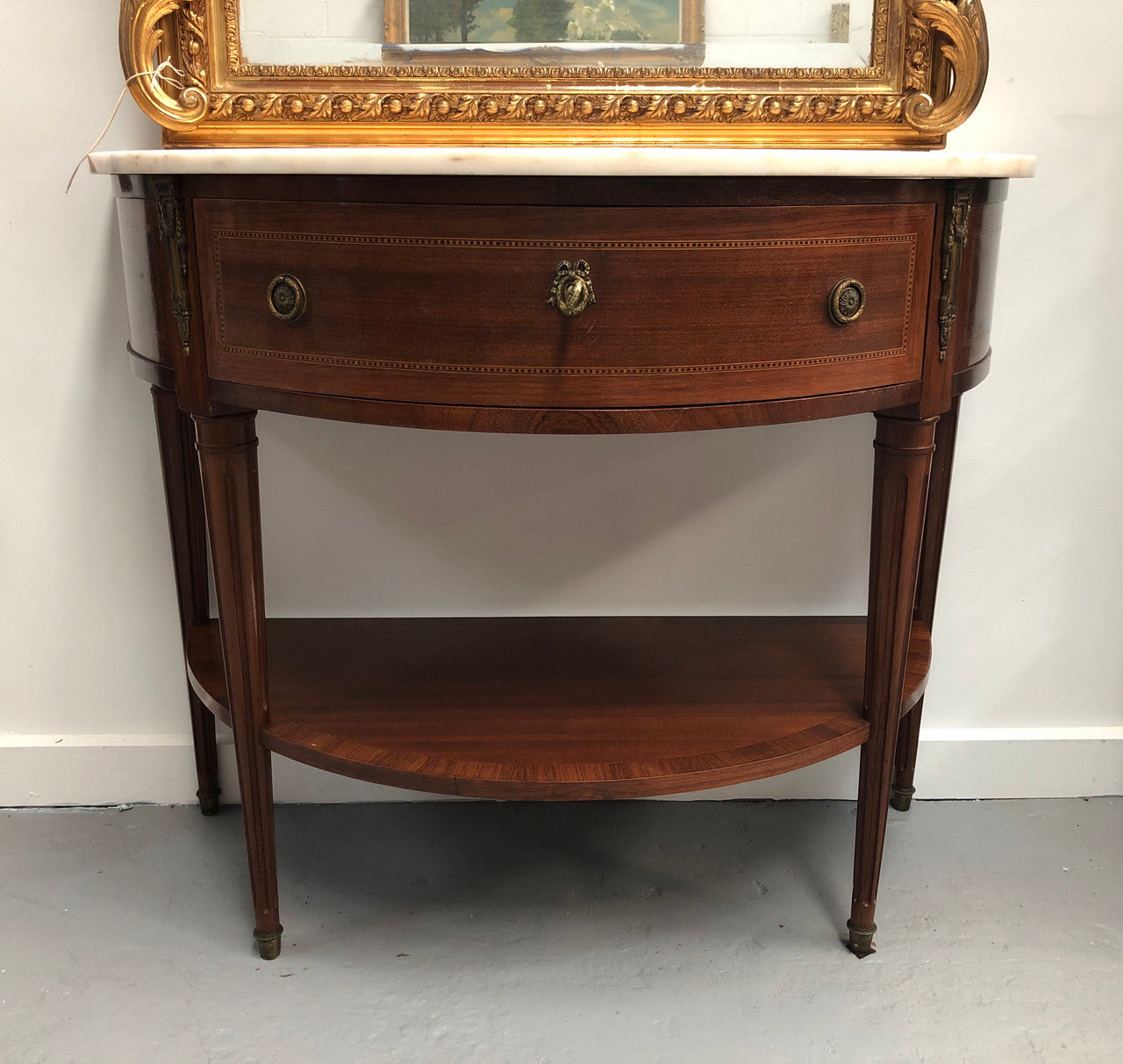 French marble top half round console table. It has beautiful marquetry inlay and ormolu mounts with a single drawer. In good original condition.