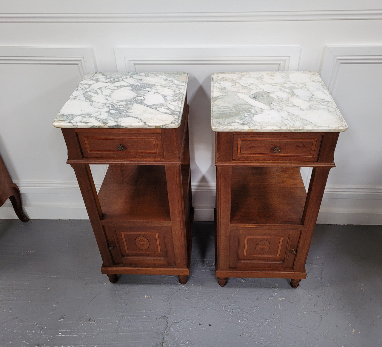 Pair of Antique French Oak Louis XVI style marble top bedside cabinets. They have decorative inlay and have been sourced from France. They are in good original detailed condition.