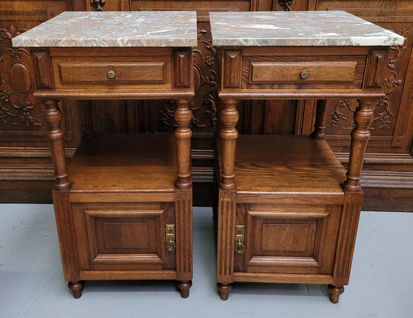 Pair of French Antique Oak marble top bedsides Henry II style. They have a drawer, cupboard and an open shelf for all your storage needs. They have been sourced from France and are in good original detailed condition.