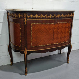 Vintage French style marble top two door half-moon buffet with beautiful decorative brass gilt mounts. In good original detailed condition.